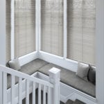 brown/grey wooden venetian window blinds covering large windows on the landing of stairs
